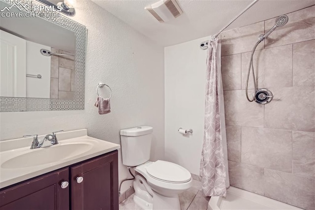 bathroom featuring a textured ceiling, vanity, toilet, and walk in shower