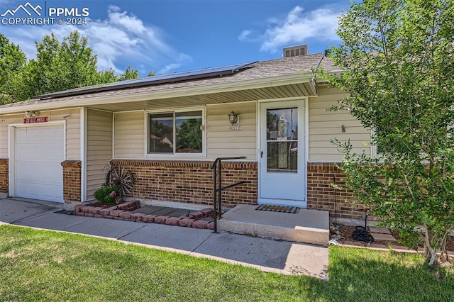 property entrance featuring solar panels, a porch, and a garage