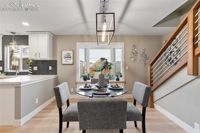 dining space featuring light wood-type flooring and sink