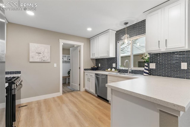 kitchen with sink, hanging light fixtures, light hardwood / wood-style flooring, appliances with stainless steel finishes, and white cabinetry