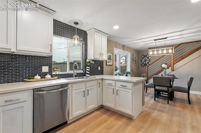 kitchen with dishwasher, white cabinets, sink, decorative light fixtures, and light hardwood / wood-style floors