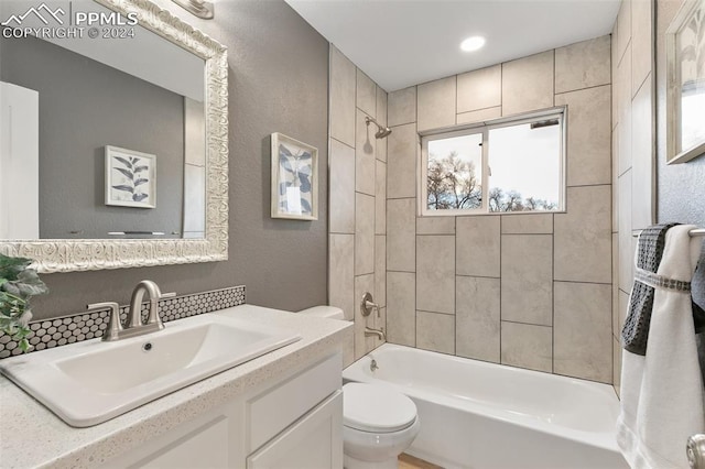 full bathroom featuring vanity, toilet, and tiled shower / bath