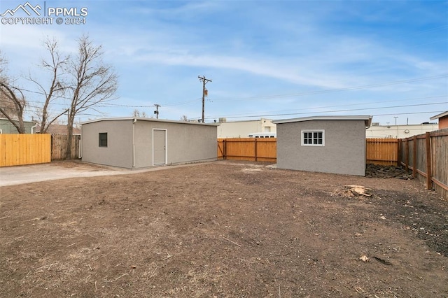 rear view of property featuring an outdoor structure