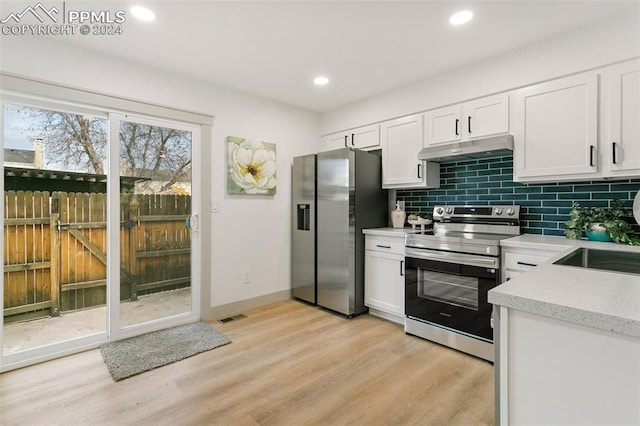 kitchen featuring backsplash, white cabinets, stainless steel appliances, and light hardwood / wood-style floors