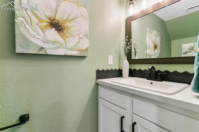 bathroom with vanity and lofted ceiling