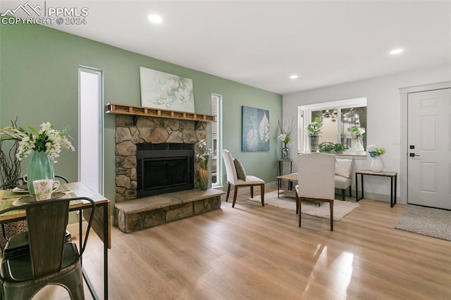 sitting room with light hardwood / wood-style floors and a stone fireplace