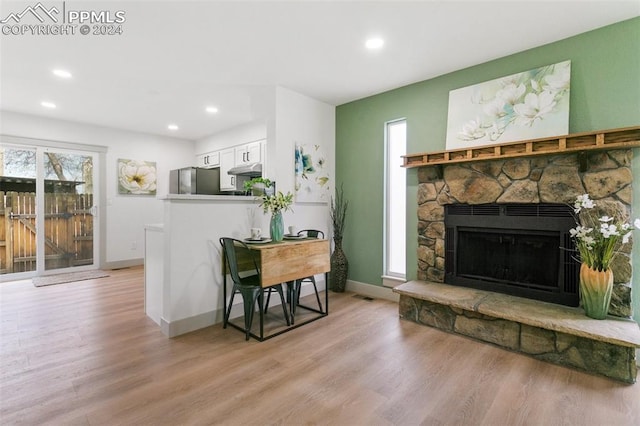 interior space with a stone fireplace and light hardwood / wood-style flooring