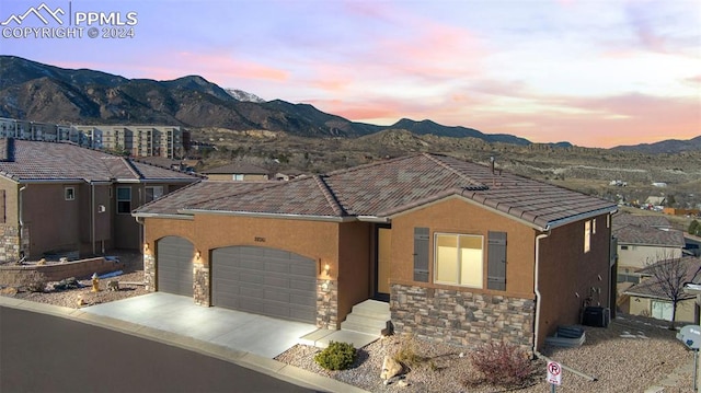 view of front facade with a mountain view and a garage