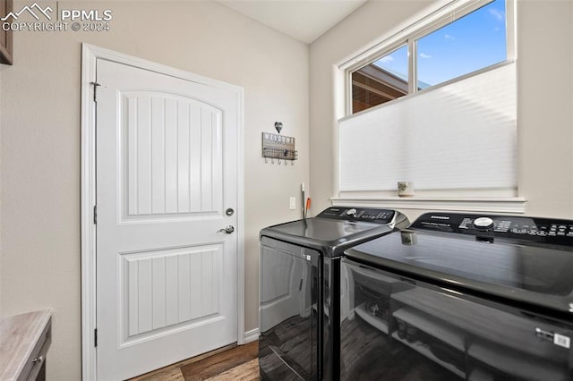 washroom with washer and dryer and wood-type flooring