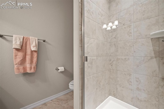 bathroom featuring toilet and a shower with door