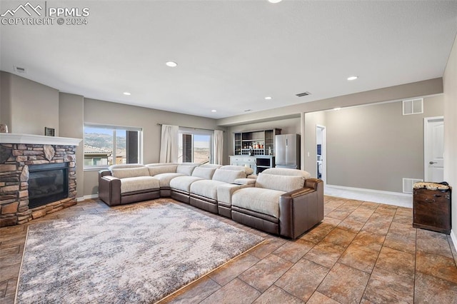 living room featuring a stone fireplace