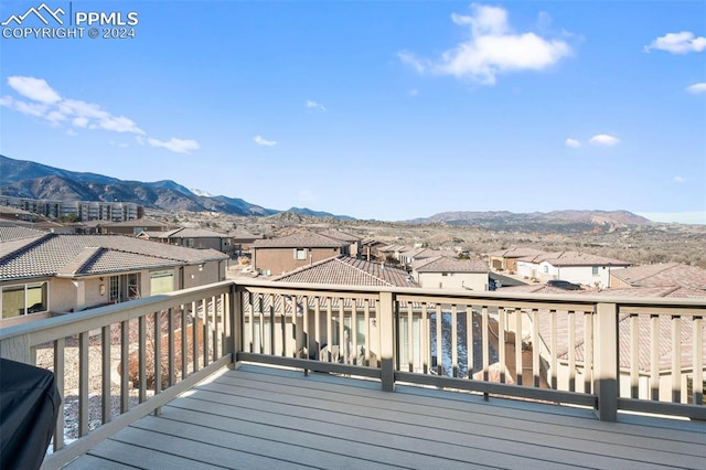 wooden deck with a mountain view and a grill