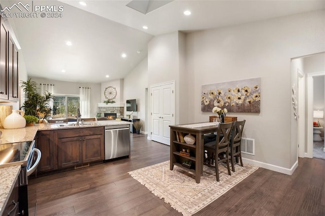 kitchen featuring appliances with stainless steel finishes, dark hardwood / wood-style flooring, light stone counters, sink, and high vaulted ceiling