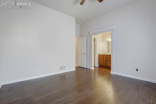 unfurnished bedroom featuring dark hardwood / wood-style flooring, ensuite bathroom, and ceiling fan