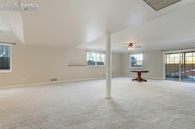 basement with light carpet, ceiling fan, and ornamental molding