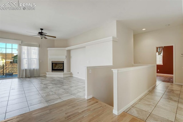 unfurnished living room with ceiling fan and light tile patterned floors