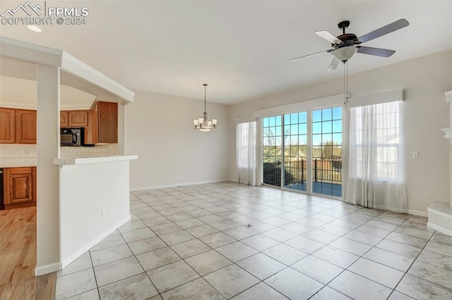 interior space featuring ceiling fan with notable chandelier