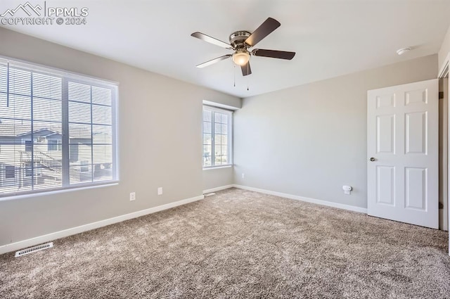 spare room with ceiling fan and carpet