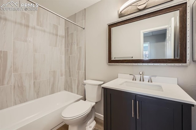 full bathroom with tiled shower / bath, vanity, and toilet