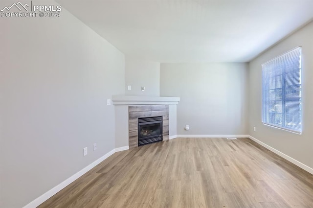 unfurnished living room featuring a fireplace and light wood-type flooring