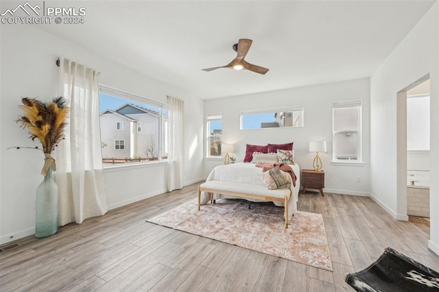 bedroom with connected bathroom, multiple windows, ceiling fan, and light hardwood / wood-style floors