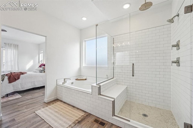 bathroom with hardwood / wood-style floors and shower with separate bathtub