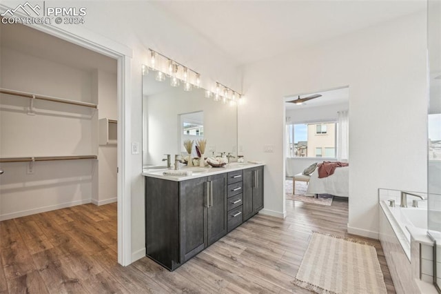 bathroom with a tub, ceiling fan, vanity, and hardwood / wood-style flooring