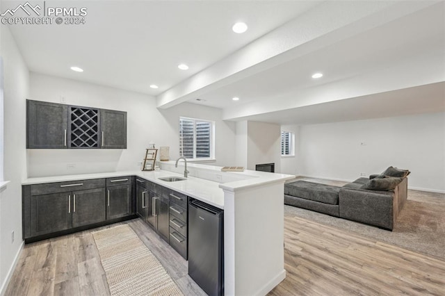 kitchen featuring light hardwood / wood-style floors, refrigerator, kitchen peninsula, and sink