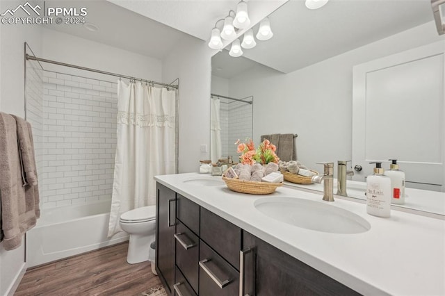 full bathroom featuring toilet, wood-type flooring, vanity, and shower / tub combo with curtain