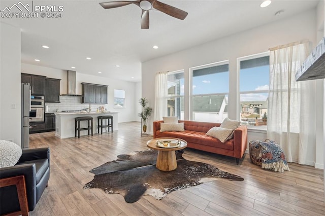 living room with light wood-type flooring and ceiling fan