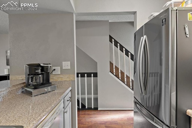 kitchen featuring light stone counters, dark hardwood / wood-style flooring, and appliances with stainless steel finishes