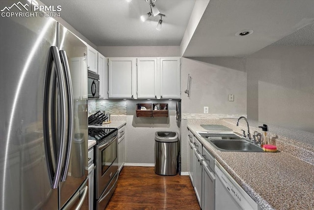 kitchen featuring dark hardwood / wood-style flooring, white cabinetry, sink, and appliances with stainless steel finishes