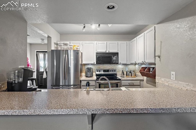 kitchen with white cabinets, sink, decorative backsplash, appliances with stainless steel finishes, and kitchen peninsula