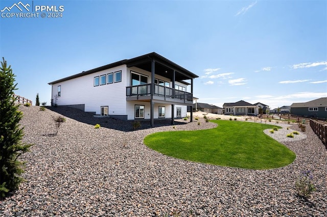 back of property featuring a balcony and a lawn