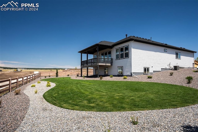 back of house with cooling unit, a balcony, a yard, and a rural view