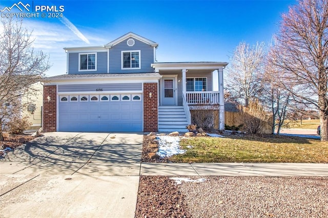 front of property with covered porch, a garage, and a front lawn