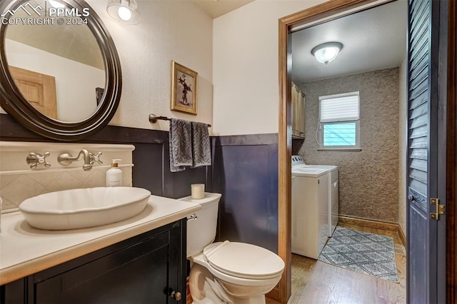 bathroom with vanity, hardwood / wood-style flooring, toilet, and washer and clothes dryer