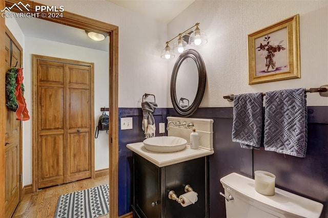 bathroom with hardwood / wood-style flooring, vanity, and toilet