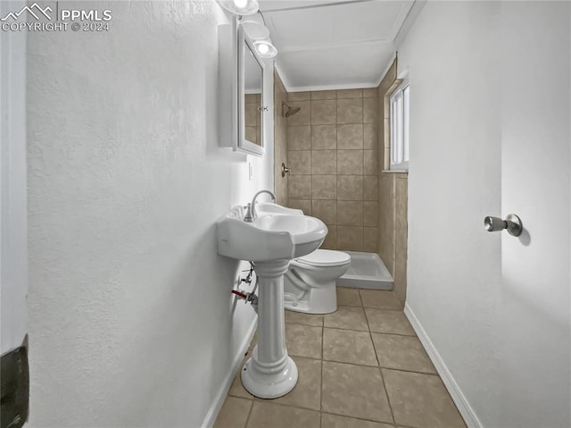 bathroom with tiled shower, tile patterned flooring, and toilet