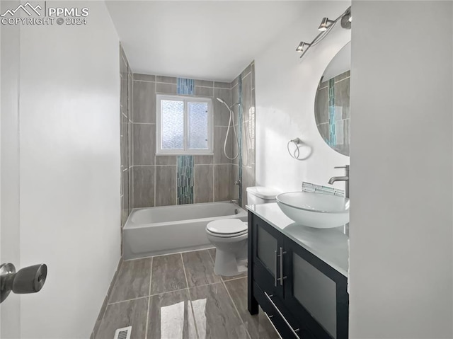 full bathroom featuring vanity, toilet, and tiled shower / bath