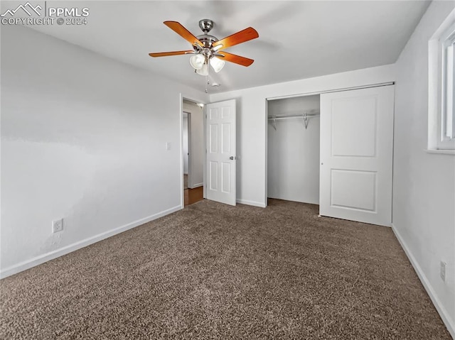 unfurnished bedroom featuring ceiling fan, a closet, and dark carpet