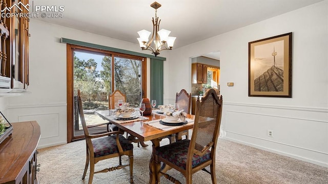 dining room featuring light colored carpet and a notable chandelier