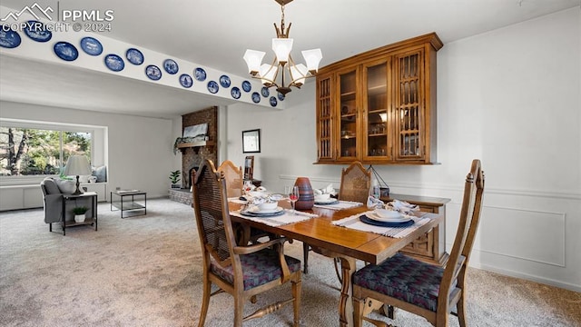 dining space with a notable chandelier, a fireplace, and light carpet