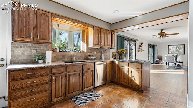 kitchen featuring tasteful backsplash, stainless steel dishwasher, ceiling fan, sink, and light hardwood / wood-style flooring