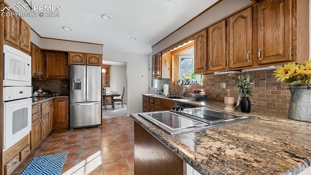 kitchen with decorative backsplash, tile patterned floors, white microwave, sink, and stainless steel fridge with ice dispenser