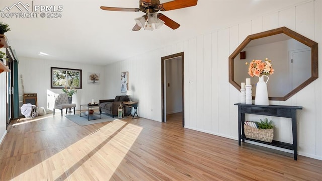 sitting room with ceiling fan and hardwood / wood-style flooring