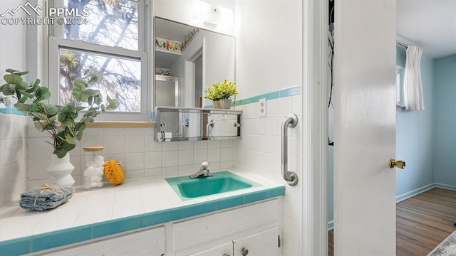 bathroom featuring decorative backsplash, hardwood / wood-style floors, and vanity