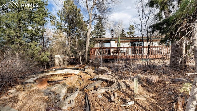 back of house with a wooden deck