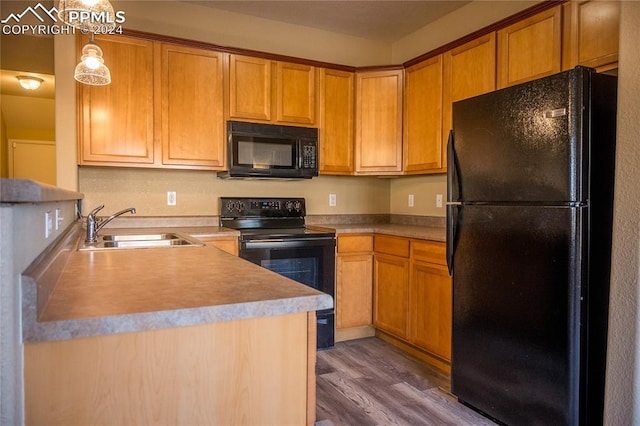 kitchen with black appliances, dark hardwood / wood-style floors, sink, and hanging light fixtures