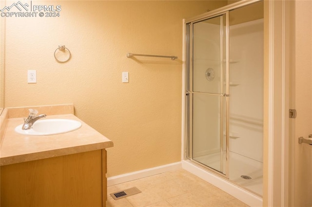 bathroom featuring vanity, tile patterned floors, and an enclosed shower